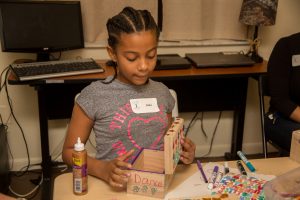 Child building a keepsake box of her own