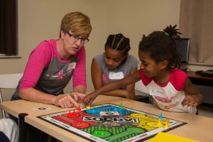 Children and volunteers playing a board game