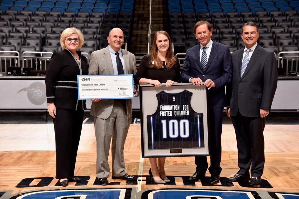 Betsey Bell accepting a check from Orlando Magic Philanthropy team